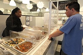 Rochelle Holmes prepares a plate of food, while taking the order of customer Jacob Quijano, of Holland at her restaurant Daddio's 2, March 23, 2022. (J.R. Valderas)