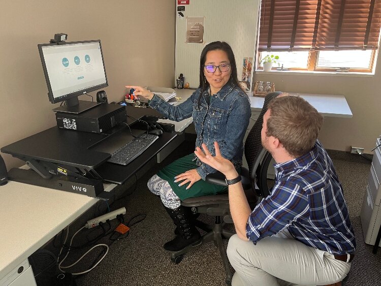 DNL employees, Angela Mitchell and Michael Niederer, discuss customer information.