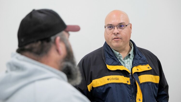 Eric Hanna, president and CEO of Michigan Community Capital, speaks to an attendee at the Robinson Landing Black Party.