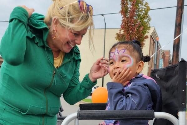 Shel Bell Sullivan paints the face of a young girl at the Block Party. (Gentex)