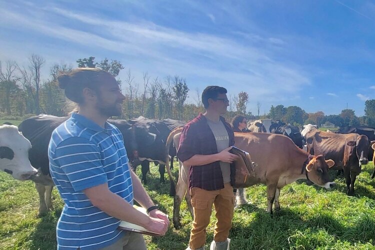 Kyle Hildebrandt and Alex Svoboda discuss pasture health with a local farmer.