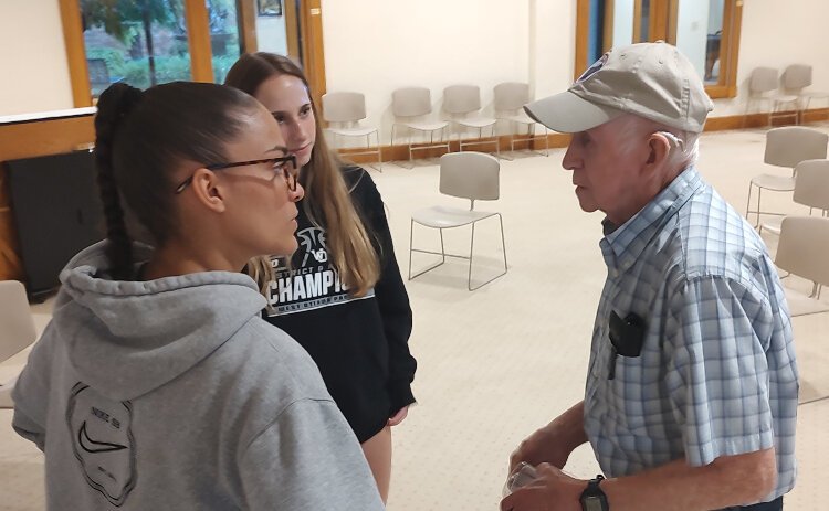 West Ottawa basketball players Taylor Catton, center, and Gabby Reynolds speak to a man following a Q&A session at Evergreen Commons.