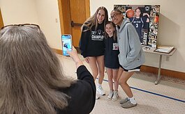 West Ottawa basketball players Taylor Catton, left, and Gabby Reynolds, right, have their photo taken with a young fan following a Q&A session at Evergreen Commons.