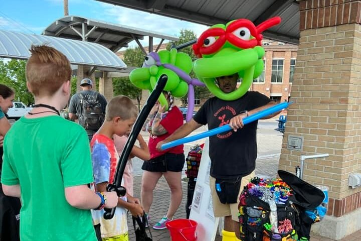 Steve Tamayo makes balloon animals for kids at the Block Party. (Downtown Holland)