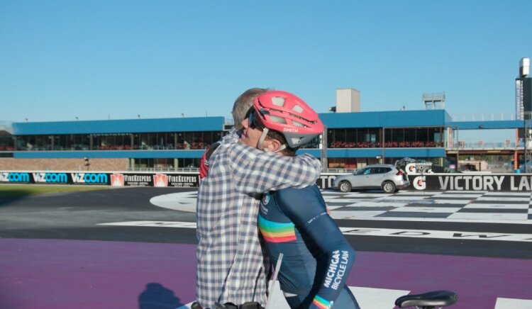 Jon Ornée hugs his dad after setting a new world record for a 100-mile bike ride while drafting.