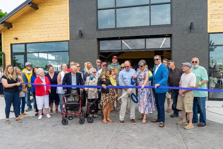 Mark Powers cuts the blue ribbon to officially open Tanglefoot Park with the support of Village board members. (Brittany Meyers)