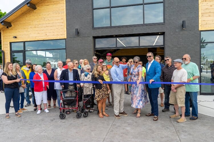 Mark Powers cuts the blue ribbon to officially open Tanglefoot Park with the support of Village board members. (Brittany Meyers)