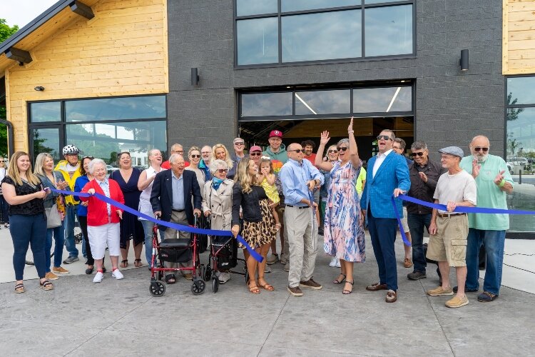 Mark Powers cuts the blue ribbon to officially open Tanglefoot Park with the support of Village board members. (Brittany Meyers)