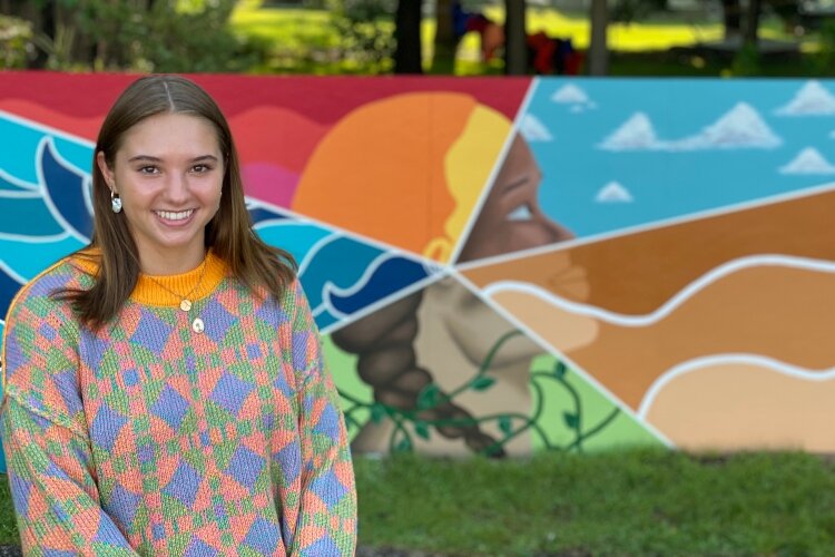 Inez Allard stands in front of the mural she created titled "Mother Nature."