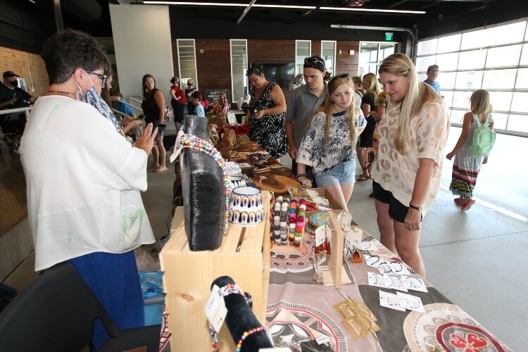 Jennifer Lindstrom, of Varna, Illinois, her daughter Brielle Lindstrom and her nephew Owen Lindstrom, look at the crafts of The Bridge in the Festival Mercado section of the International Festival of Holland at the Holland Civic Center, August 21, 20