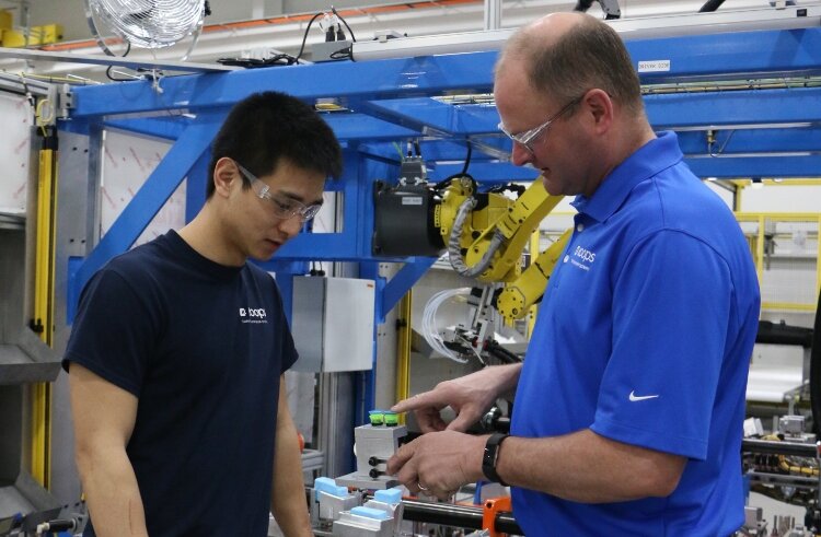 Koops Automation Systems team members work together to assemble an automated system.