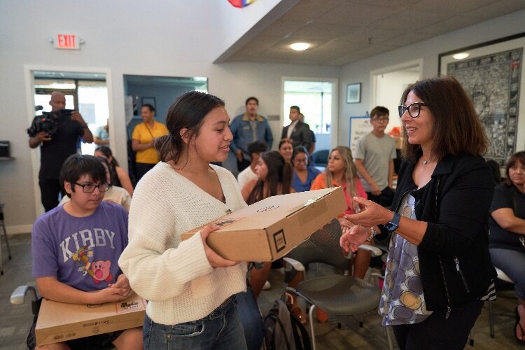 Michelle Gilbert, VP at Comcast, presents a laptop to a LAUP youth. (Comcast)