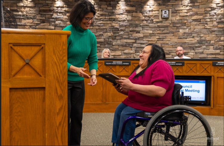 Holland Human/International Relations Manager Esther Fifelski hands the Social Justice Award for accessibility to Lucia Rios during a ceremony this month.