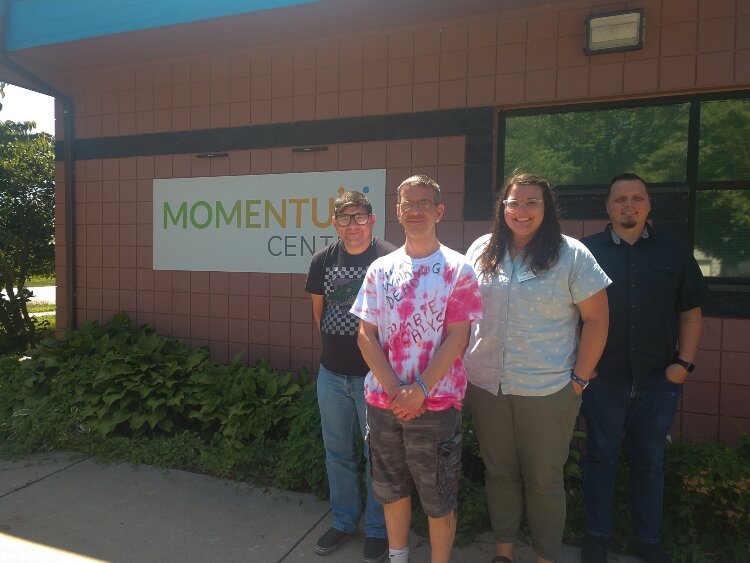 Momentum Center staff and members pose outside the nonprofit's new Holland facility at 345 W. 14th St. From left are members Steve Savage and James Dykstra and Program Coordinator Sarah Streng and Chief Funding Officer Caleb Zokoe.
