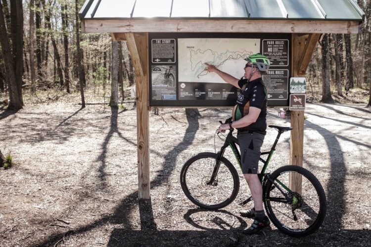 Volunteer Mark Stoll explains the routes and their difficulties at the trail head of mosquito Creek Trails.