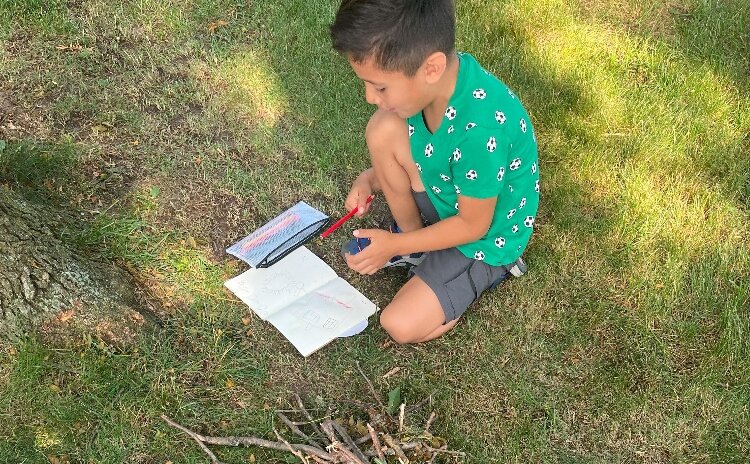 A boy reads a book at an ODC summer program.