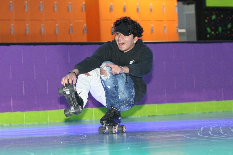 Joe Cruz, of Holland, does a “shoot-the-duck” move while roller skating at RollXscape Skating Center’s grand opening in Holland Township, Nov. 4.