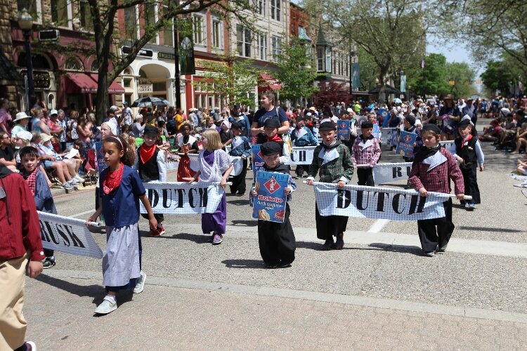 Students of Holland Christian’s Rose Park Elementary School walk down 8th Street in downtown Holland while participating   in the Kinderparade on May 12.