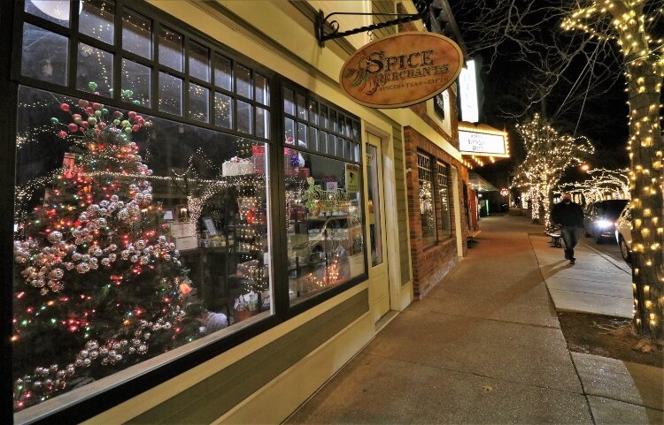 Brightly decorated window displays in downtown Saugatuck enhance main street's decorated trees.  