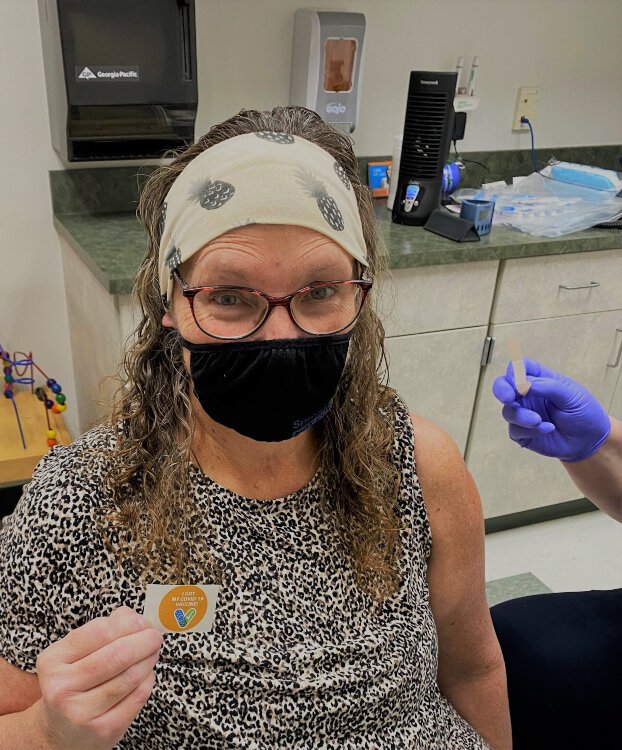 Sharon Weems, personal health assistant for the Allegan County Health Department, recieves her first dose of the COVID-19 vaccine.