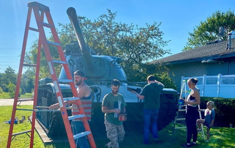 Members of the Gentex V.E.T.S. paint the tank in front of the American Legion Post. (Gentex)