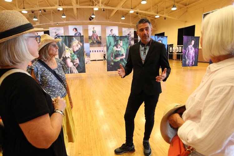 Dutch photographer Rem van den Bosch, center right, speaks  to visitors about his “Zeeland Girl” photo exhibition at the Holland Armory, May 13.