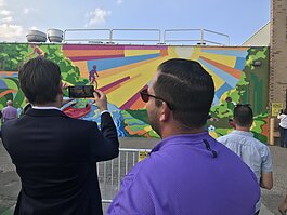 Mayor Michael Taylor “plays soccer” against the kids in Trailblazer, the new mural in Sterling Heights.