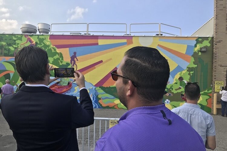 Mayor Michael Taylor “plays soccer” against the kids in Trailblazer, a mural in Sterling Heights, in 2021.