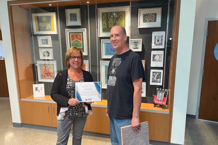 Harrison Township-based artist David Moroski poses in front of the Featured Artist showcase at the Sterling Heights Community Center in the fall of 2022.