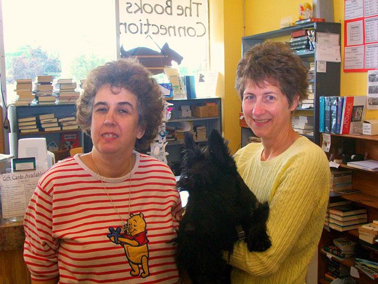 The Books Connection manager Charlotte Grombelski and owner Kathleen Mahinske pose with Darby.
