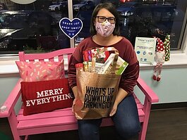 Missy LaRussa of Kitchen Creations holds a complimentary tote in downtown Farmington