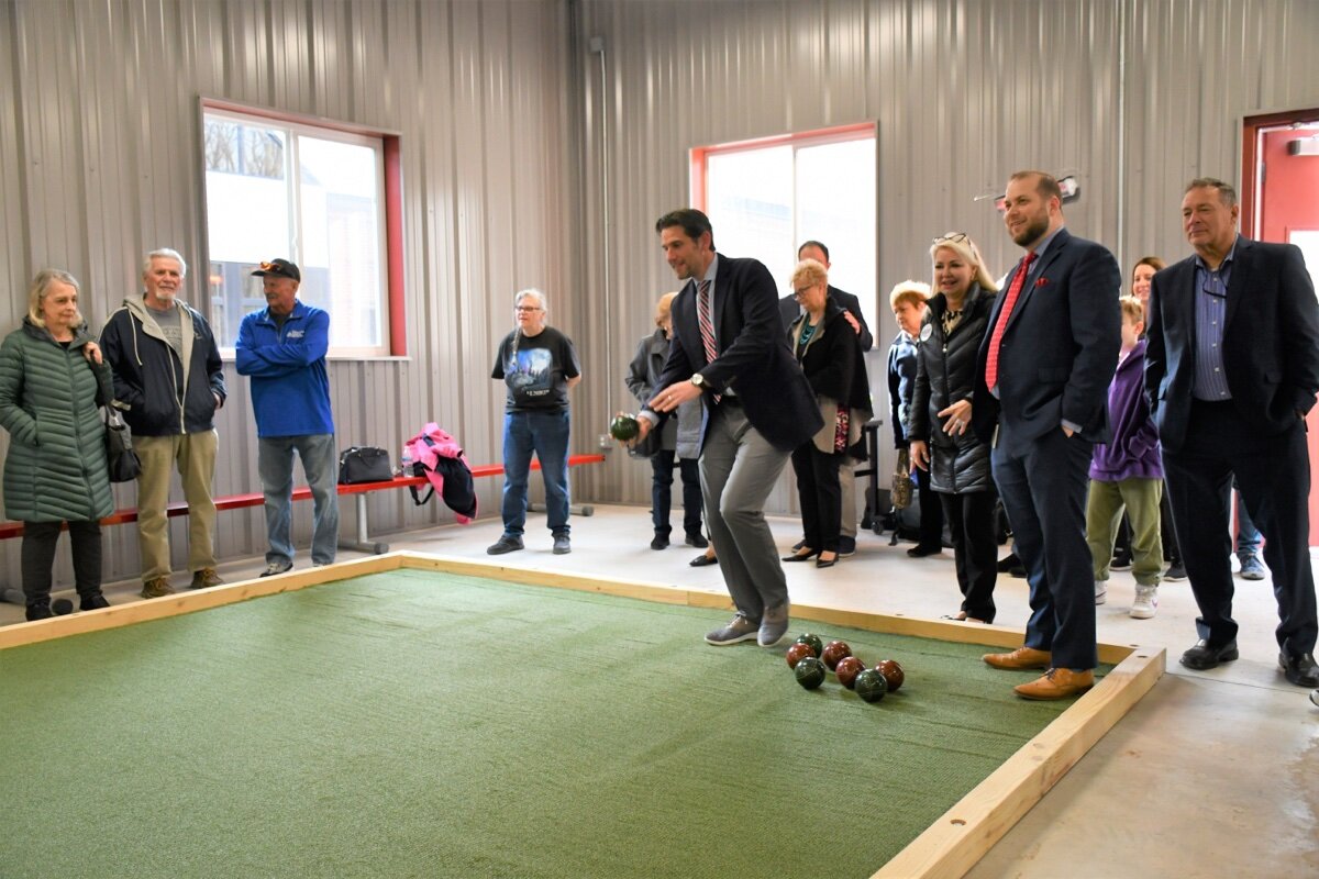 Sterling Heights Mayor Michael C. Taylor throws the ceremonial first bocce ball at the city's new Bocce Barn.