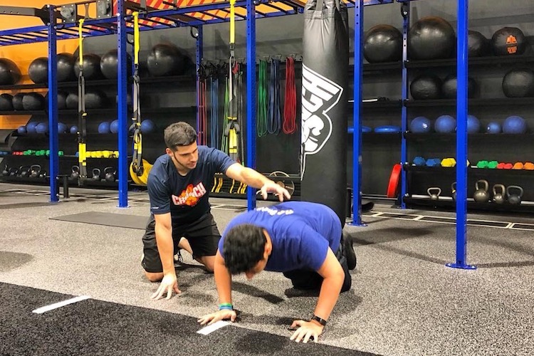 Trainer working with member at Crunch Fitness