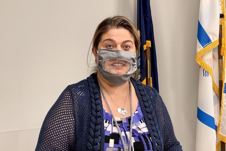 Susan Kattula models a mask made by Klodia Gossaiux for the deaf community.