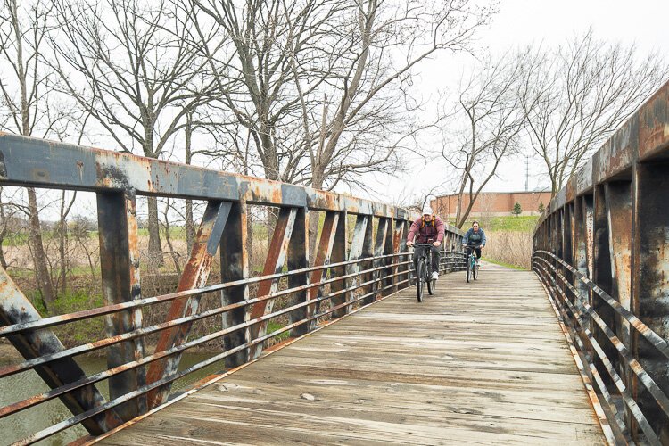 Cyclists cross a bridge at George George Park.