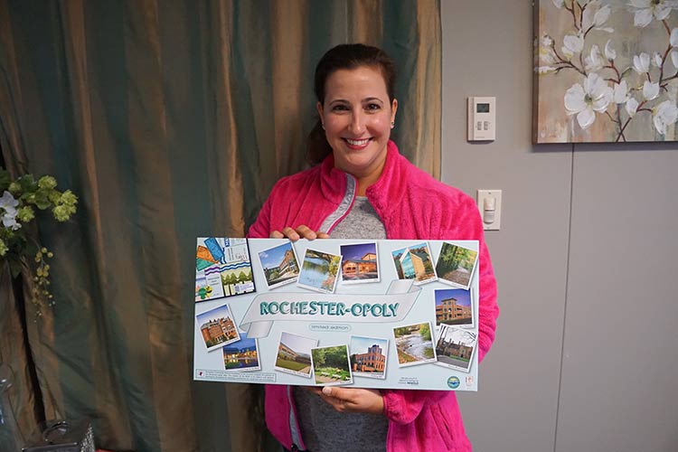 Lynne Vettraino displays her new game, Rochester-opoly.