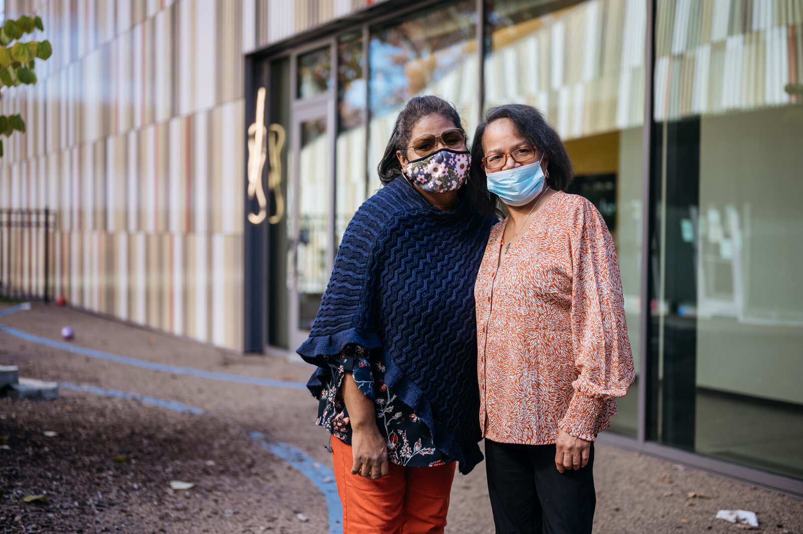 Early education teachers Nicole Clark and Tammie Dailey stand in the toddler courtyard. Clark says she loves how every classroom floods with light and teachers and students can experience the outdoors throughout the day.