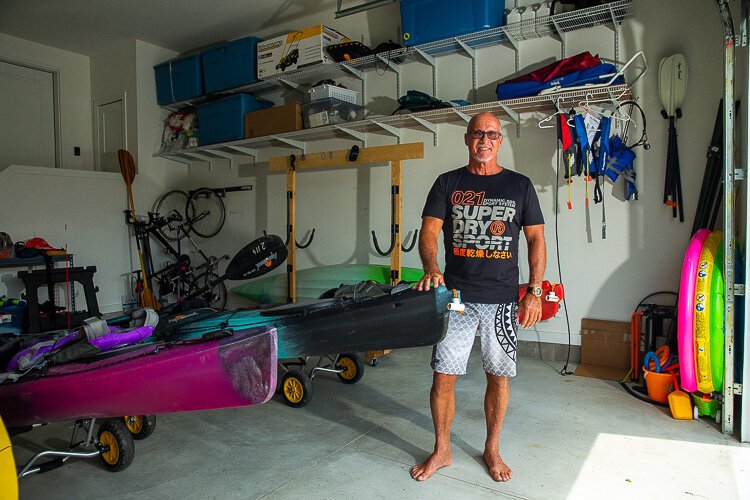 Hans Dengler stands in his garage with his kayaks.
