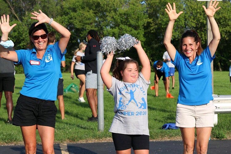 Friendship Cheer Program instructors Kathy Smith and Maria Streberger cheering with Gracie Trocino.