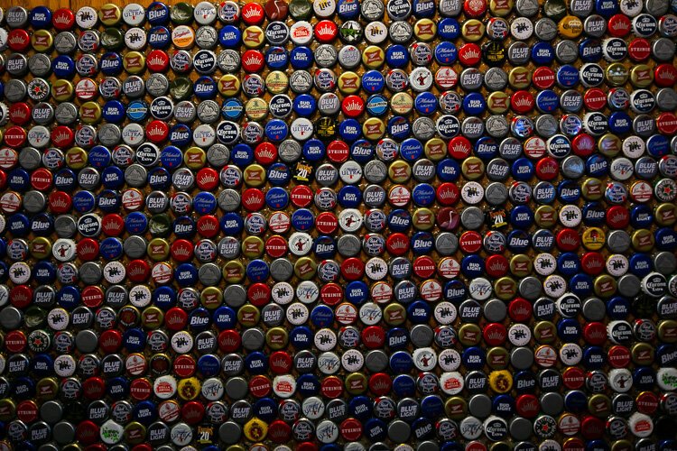 Bottle cap collection decorating the front vestibule at The Kozy Lounge.