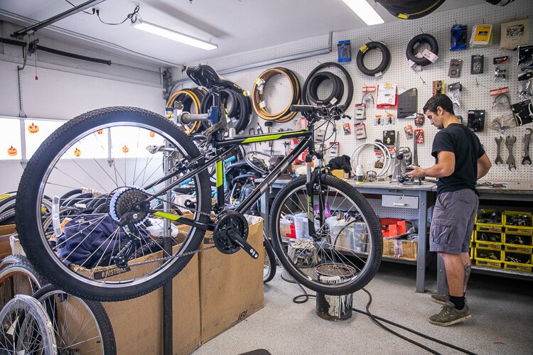 A worker at Tim's Bike Shop examines some bike parts.