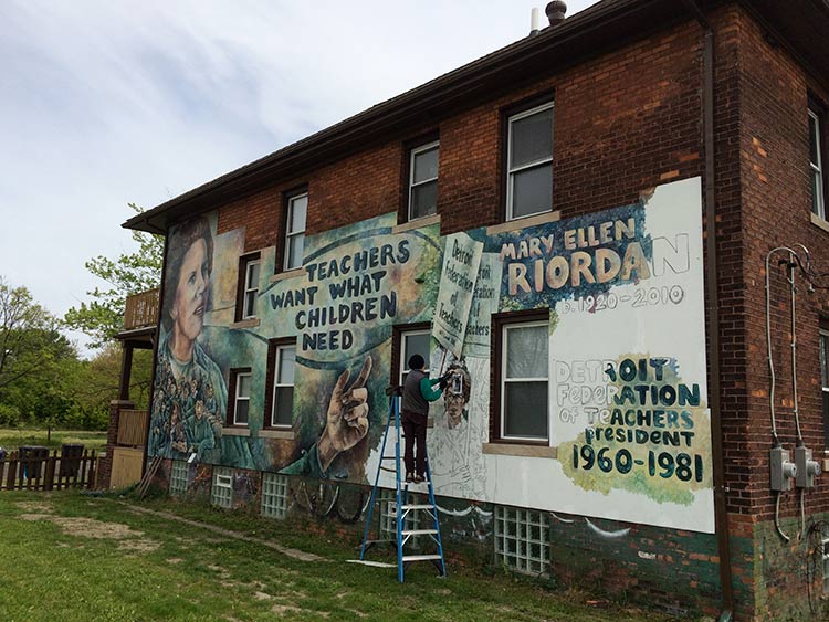 Artist Nicole MacDonald painting the last sections of the Mary Ellen Riordan mural earlier this spring. Photo by Jon Zemke