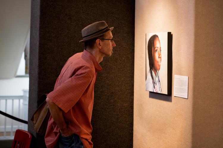 Gallery visitor takes in the exhibit at Pontiac Creative Arts Center. Photo by Nick Hagen.