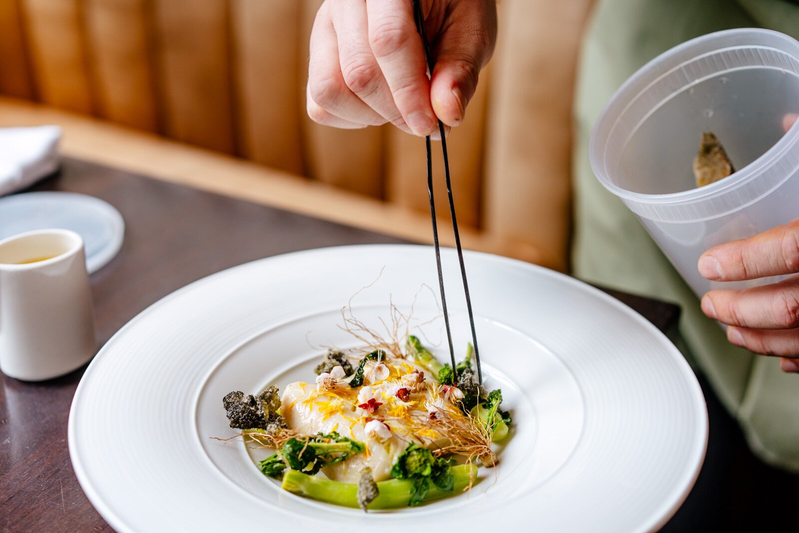 Ken Miller places cooked wild garlic roots to a roast sablefish dish. 