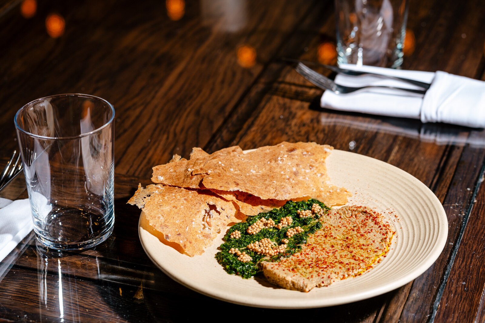 A dish made to use potentially wasted food: baba ganoush, a foraged garlic mustard pesto, and crackers made from spent bread.