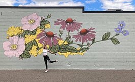 The new mural on The Vines Flower and Garden Shop with artist Mackenzie Harthun