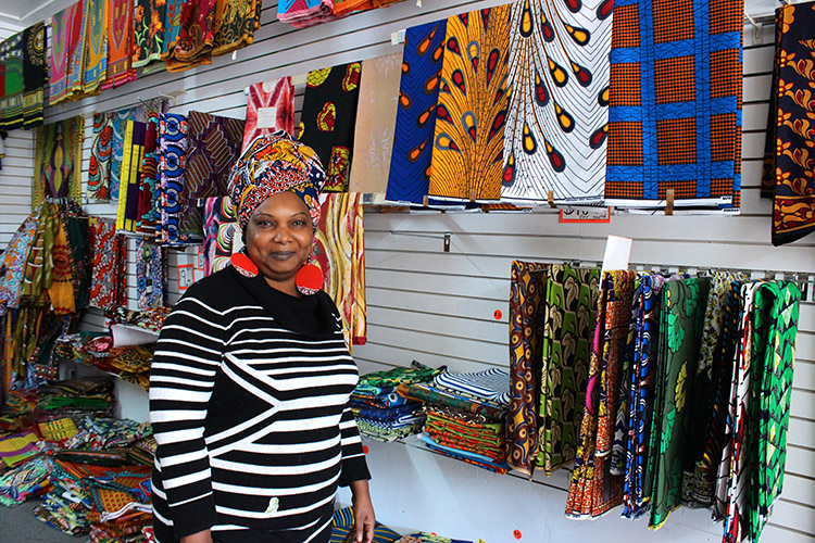 Classic Expressions owner Yemisi "Dammy" Bamisaye poses alongside some of her wares. Photo by Sarah Rose Sharp.