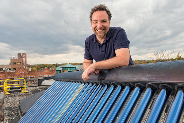 Conan Smith with a solar water heater on the roof of the Washtenaw County Administration Building