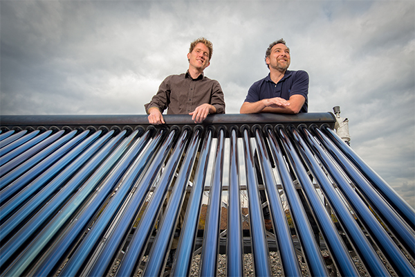 L to R Jacob Corvidae and Conan Smith with a solar water heater on the roof of the Washtenaw County Administration Building