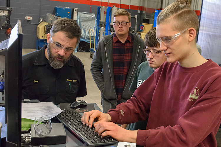 Washtenaw Community College Advanced Transportation Center students send commands to test roadside units. 